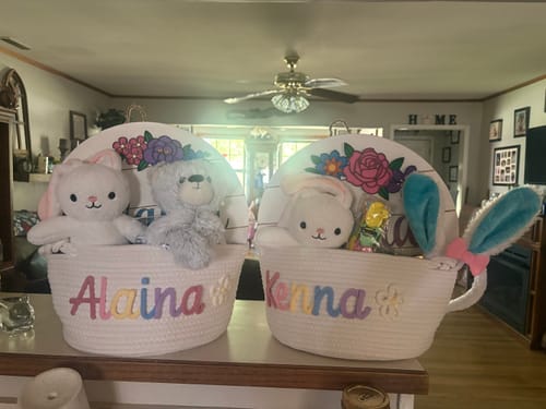 Customer's two personalized white Easter baskets filled with soft Animal Plushie Toys including bunnies and a bear.