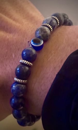 Close-up of a customer wearing a blue stone bracelet with an evil eye bead and silver spacers.