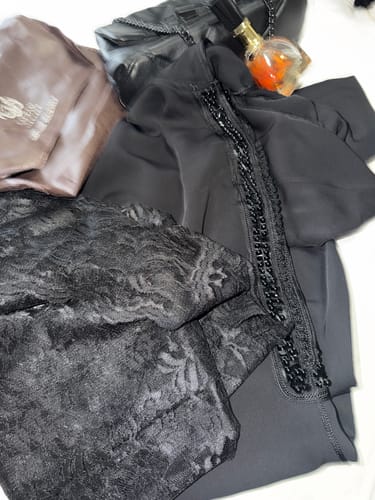 Customer's black Jellaba Amara laid out, showing the detailed beadwork and lace inner kaftan.