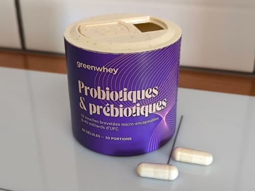 Le pot de Probiotiques & Prébiotiques d'un client, avec deux gélules blanches posées à côté.