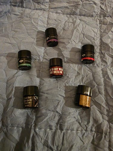 Customer's Bestsellers Set of 1ml sample vials arranged on a gray quilted blanket.