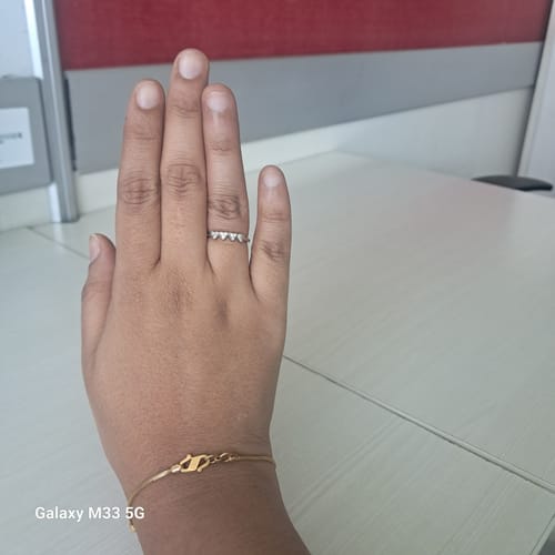 Reviewer wearing the Silver Love Ring on their finger to show its fit and heart design.