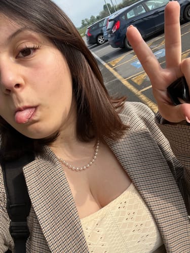 Reviewer in a playful outdoor selfie wearing the natural-looking Manga - Brown lashes with a blazer.