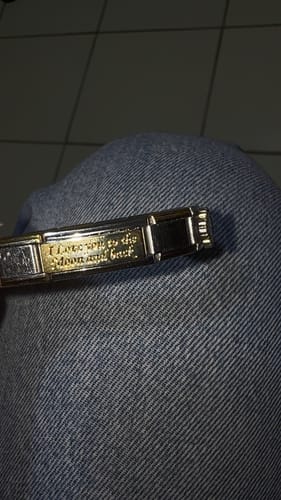 Primer plano del charm doble 'I Love You to the Moon and Back' de un cliente en su pulsera.