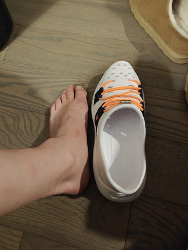 Customer comparing their foot size against the much larger Early Bird Wildpools slip-on shoe.