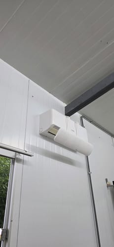 El deflector para aire acondicionado del cliente instalado en una unidad interior blanca.