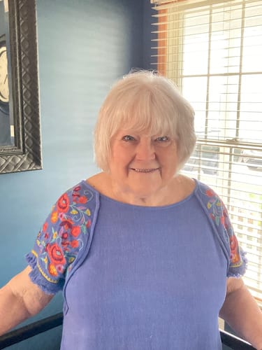 A smiling customer happy with the warranty service for her ClarityMax wireless hearing aid.