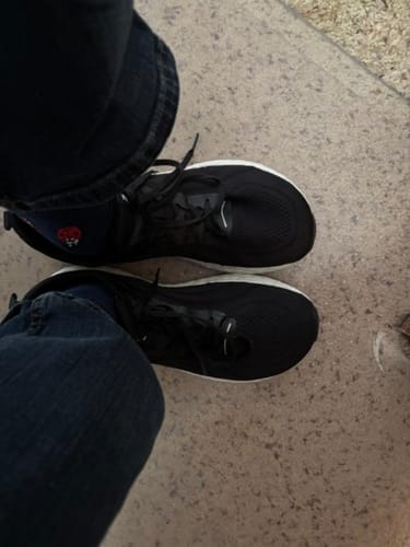 Overhead view of a reviewer wearing the black CUURT Muuv wide toe box court shoes.