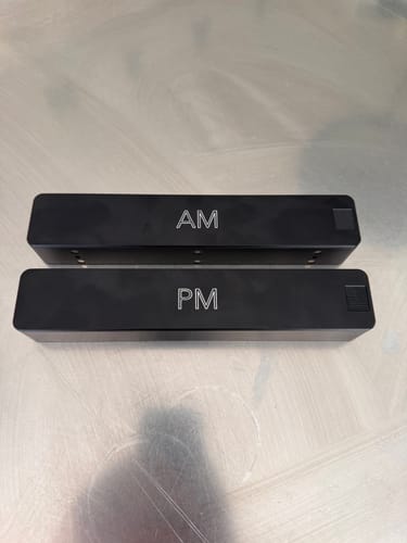 Reviewer's black metal Weekly AM-PM Vitamin Case, showing the separate AM and PM containers on a surface.