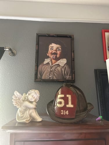 Reviewer's framed 'Boost Creativity' art print hanging on a grey wall above other decor.