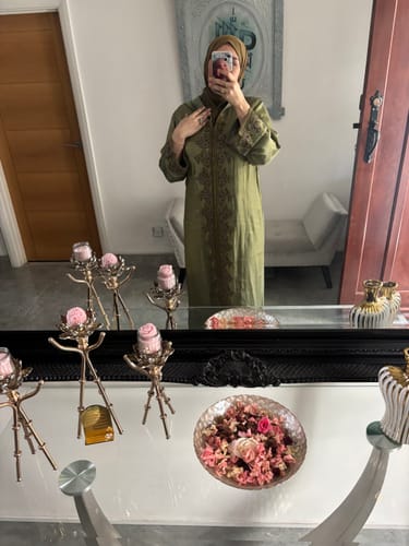 Reviewer taking a mirror selfie in the olive green Jellaba Souria, showing the detailed embroidery.