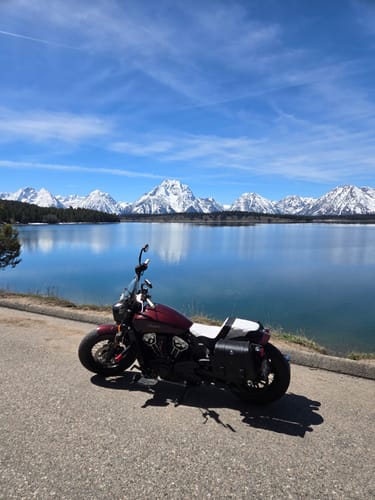 Reviewer's motorcycle with a white Saddlemen Step Up Seat parked by a scenic mountain lake.