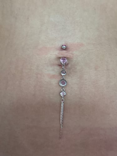 Reviewer wearing the Classico Vintage Drop Chain Belly Bar, showing its pretty pink gems and long, dangling tassel.