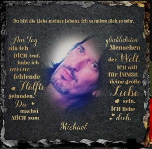 Kundenfoto des schwarzen Premium Aufstellers, der eine quadratische Gedenktafel aus Schiefer mit einem Foto und Text hält.