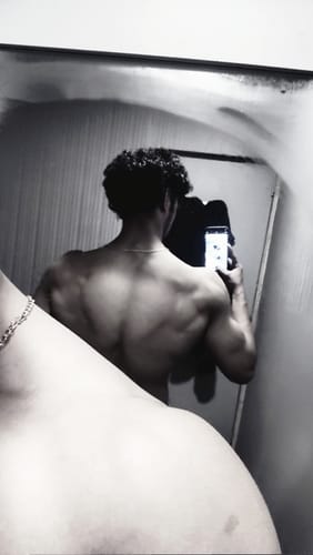 Reviewer's black and white photo showing their defined back muscles in a mirror selfie after using Dynamite Pre-Workout.