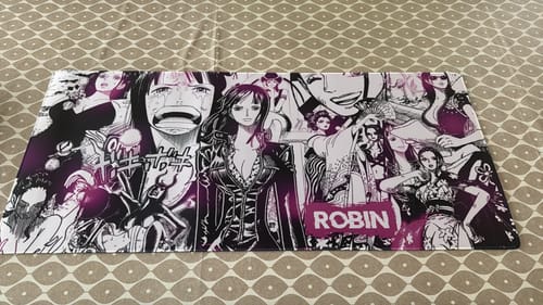Customer's custom iD Colossus mousepad with a purple anime collage design laid flat on a patterned surface.
