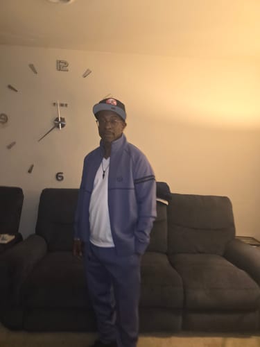 Reviewer wearing the heron-colored Orion Track Pant and matching jacket while standing indoors.