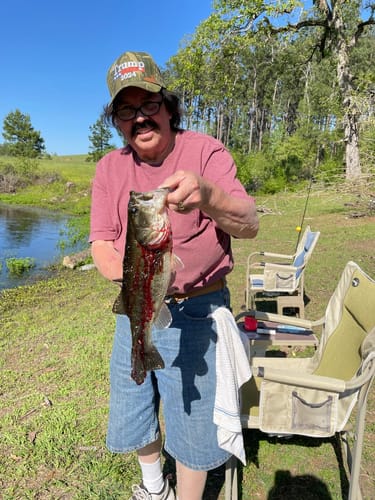 Customer who uses ClarityMax hearing aids smiling while holding a large fish he just caught.