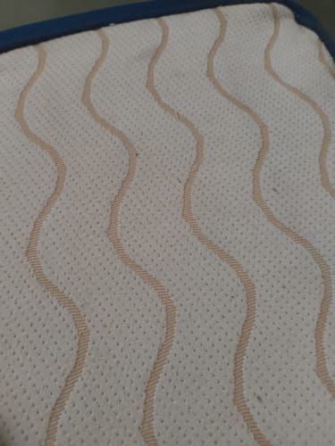 Close-up of a customer's Flo Mattress Ortho, showing the white dotted cover with a wavy tan pattern.