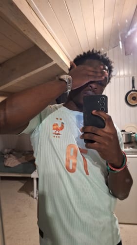 Client portant le Maillot 2026 France Extérieur bleu clair et rayé lors d'un selfie dans un miroir.