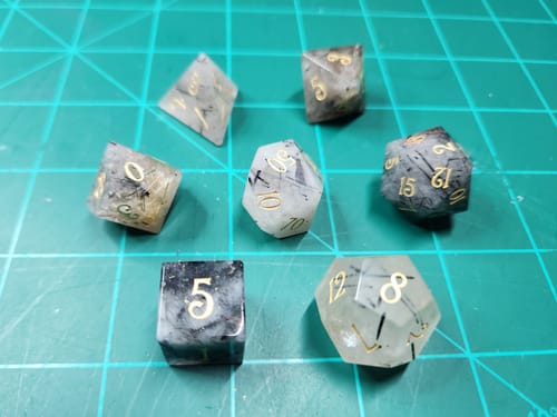 Customer's Black Rutilated Quartz gemstone dice set displayed on a green gridded mat.