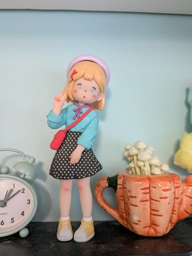 Customer's Suki My Friends Series figure with blonde hair, a blue shirt, and polka-dot skirt, making a peace sign.