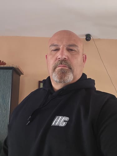 Un client portant le Hoodie HC Argenté noir, montrant le logo sur la poitrine.