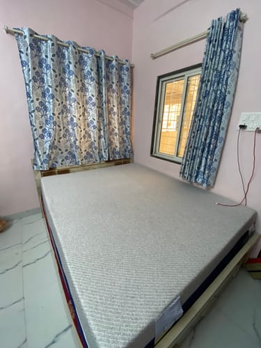 Customer's Flo mattress protector with a textured grey top shown on a bed in a bedroom setting.