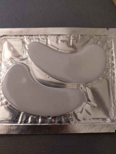 Nahaufnahme der grauen Augenpads eines Kunden in der silbernen Originalverpackung.