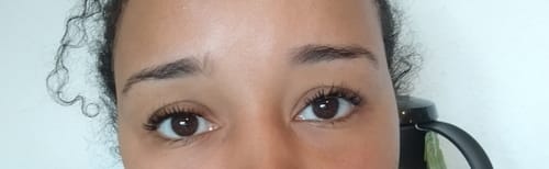 Nahaufnahme der Augen einer Kundin, die das Ergebnis der 'And so it begins' Wimpernextensions zeigt.
