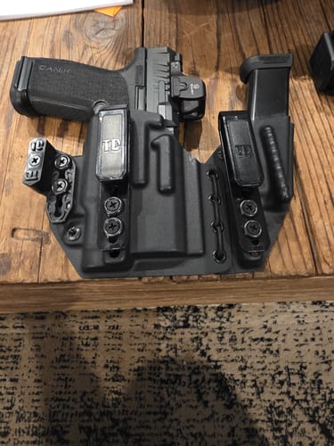 Customer's black AXIS ELITE holster holding a Canik handgun and a spare magazine on a wooden surface.