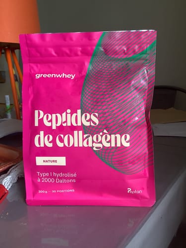 Client présentant le sachet rose vif des Peptides de Collagène, saveur Nature.