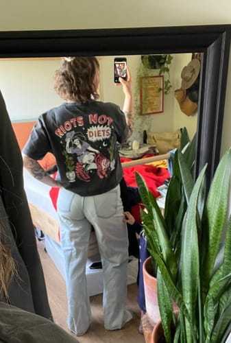 Reviewer wearing the Riots Not Diets T-Shirt, seen from the back in a mirror selfie.