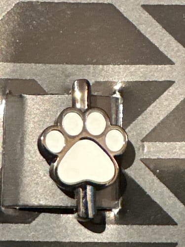Customer's close-up of the Cat Paw Charm, showing the silver-toned metal and white enamel pads.
