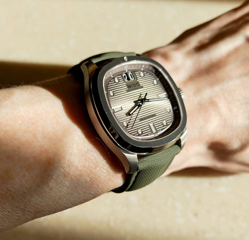 Customer's watch on their wrist, showing the green Sailcloth Rubber Deploy strap from a top-down view.