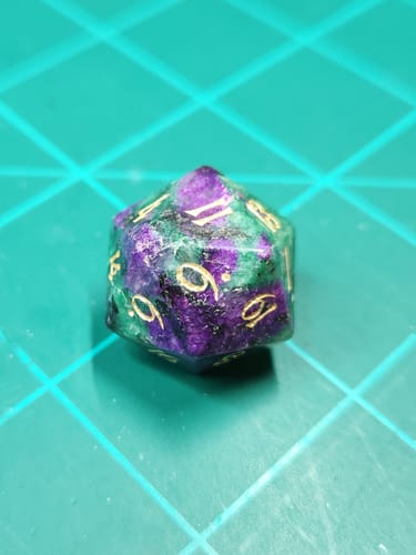 Close-up of a customer's Ruby in Zoisite gemstone die, highlighting the mottled purple and green colors with gold numbering.