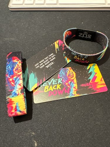 Customer's Never Back Down Tiger Bracelet and matching affirmation cards displayed on a desk.