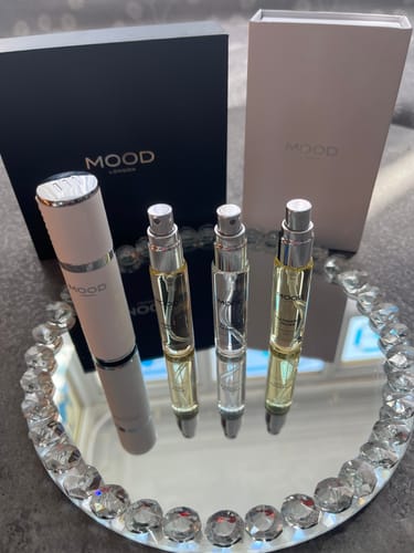 Reviewer's Spray Re-up Box Black with its white travel atomizer and three refills on a decorative mirrored tray.