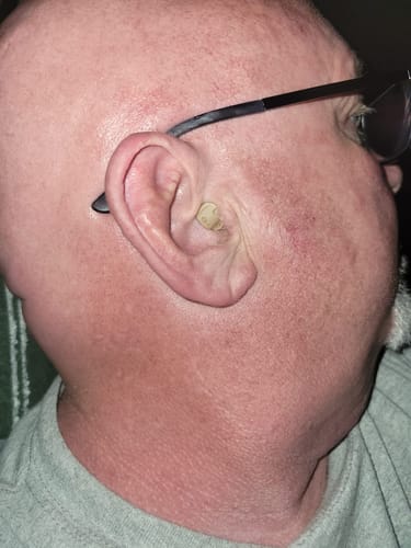 Close-up of a customer's ear, showing the small ClarityMax wireless hearing aid fitting inside.