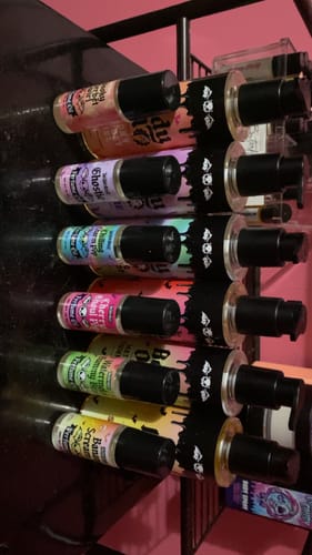 Customer's collection of colorful Brain Dead Body Spray bottles displayed in a rack.