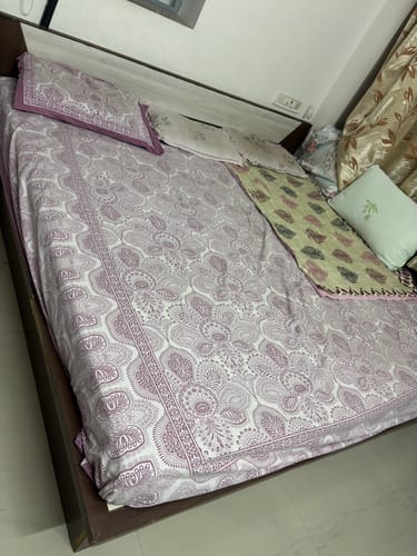 Customer's Flo Mattress Ergo on a bed, made up with a purple and white patterned sheet.