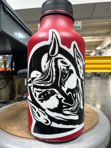 Customer's large, graphic Specialty Vinyl Sticker in black and white, applied to a red water bottle.