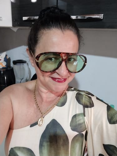 Avaliadora usando os Óculos Tropea Edição Limitada, com armação tartaruga e lentes verdes.