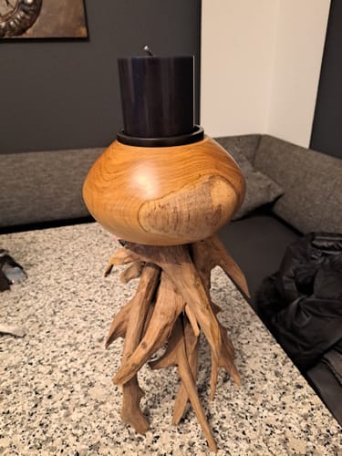 Kundenfoto des Treibholz-Kerzenständers TICO mit einer schwarzen Kerze auf einem Tisch.