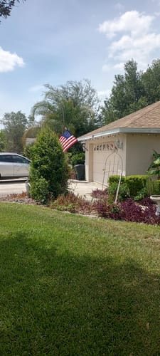 Customer's Prestige House Flag Pole with the American flag mounted on the front of a home.
