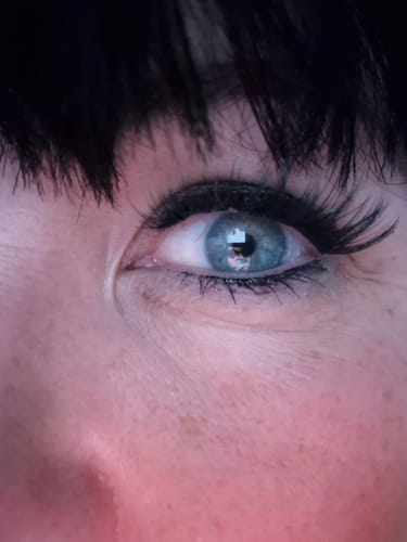 Kundin zeigt eine Nahaufnahme ihres Auges mit den aufgetragenen, langen MORE DRAMA Wimpern.