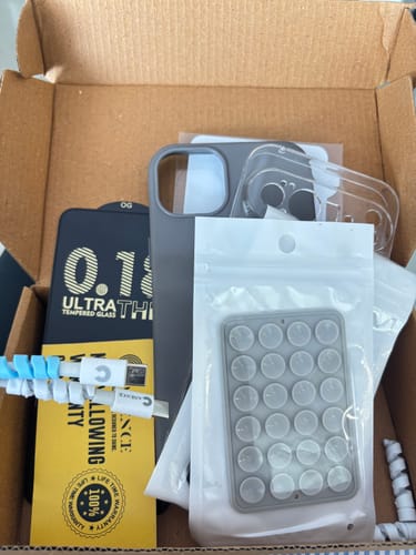 Customer unboxing the Anti Yellow Magsafe Clear Case along with other accessories in a cardboard box.