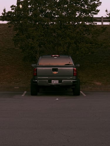 Customer's gray Chevy Silverado 1500 parked, showing its raised stance from the installed front leveling lift kit.