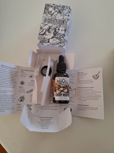 Customer's Cherry Whispers Fragrance Oil bottle displayed with its unique unfolded packaging and included dropper.