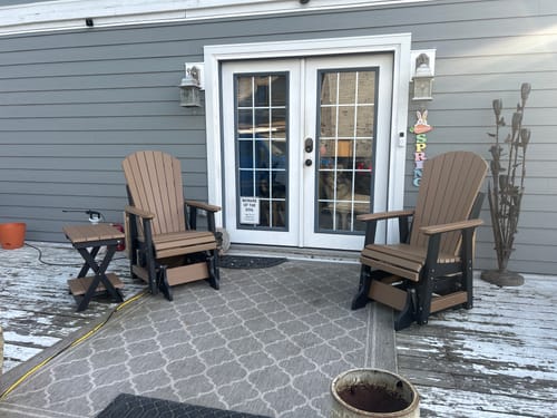 Customer's set of two Classic Adirondack Gliders and a folding end table on their home porch.